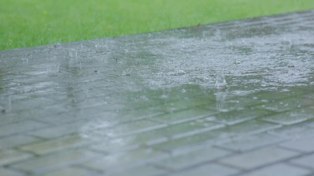 夏天白天暴雨天气，大雨落下来水坑雨滴飞溅视频素材