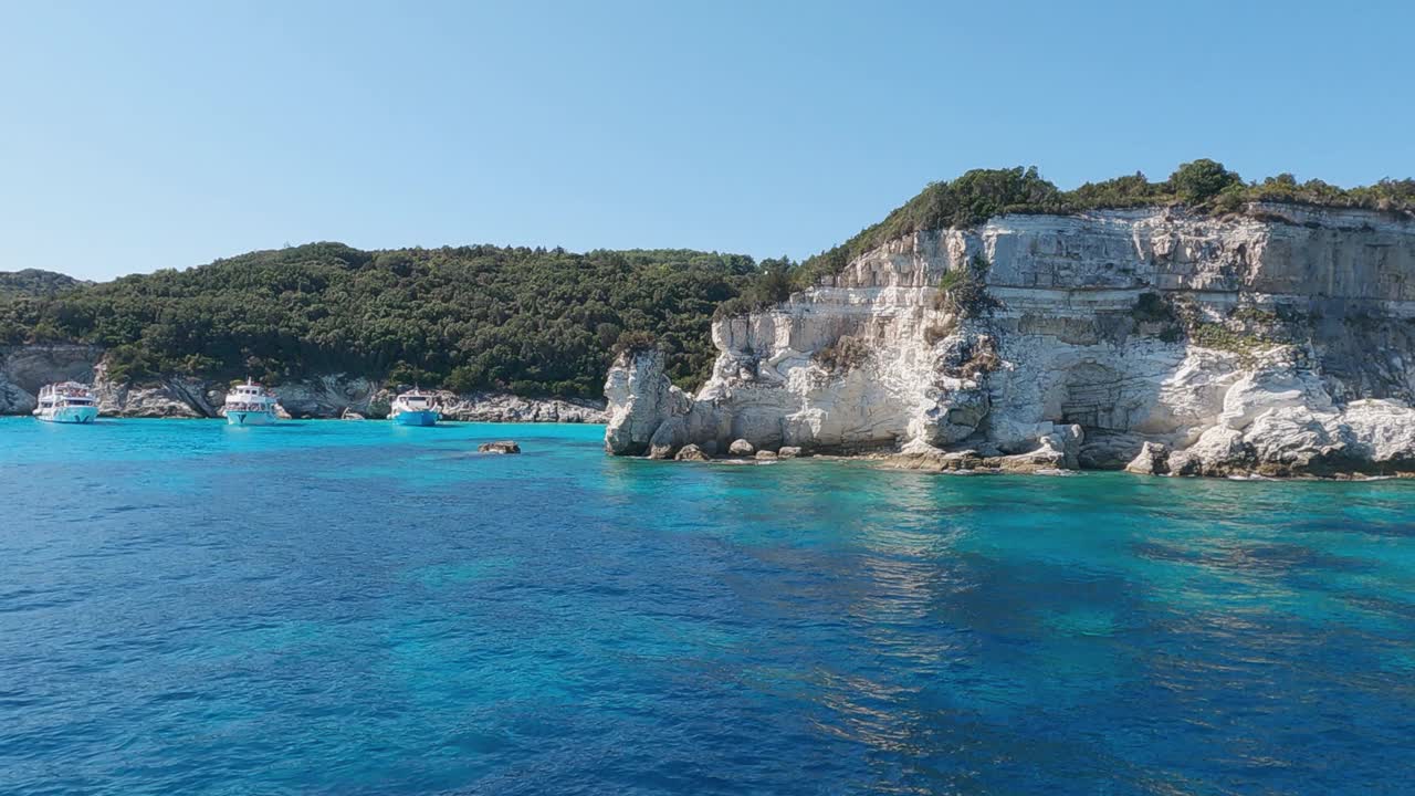 波夫沿着岩石海岸航行，在受欢迎的夏季目的地——安提帕克索斯岛，绿松石般的清澈大海，爱奥尼亚，希腊，慢镜头视频素材