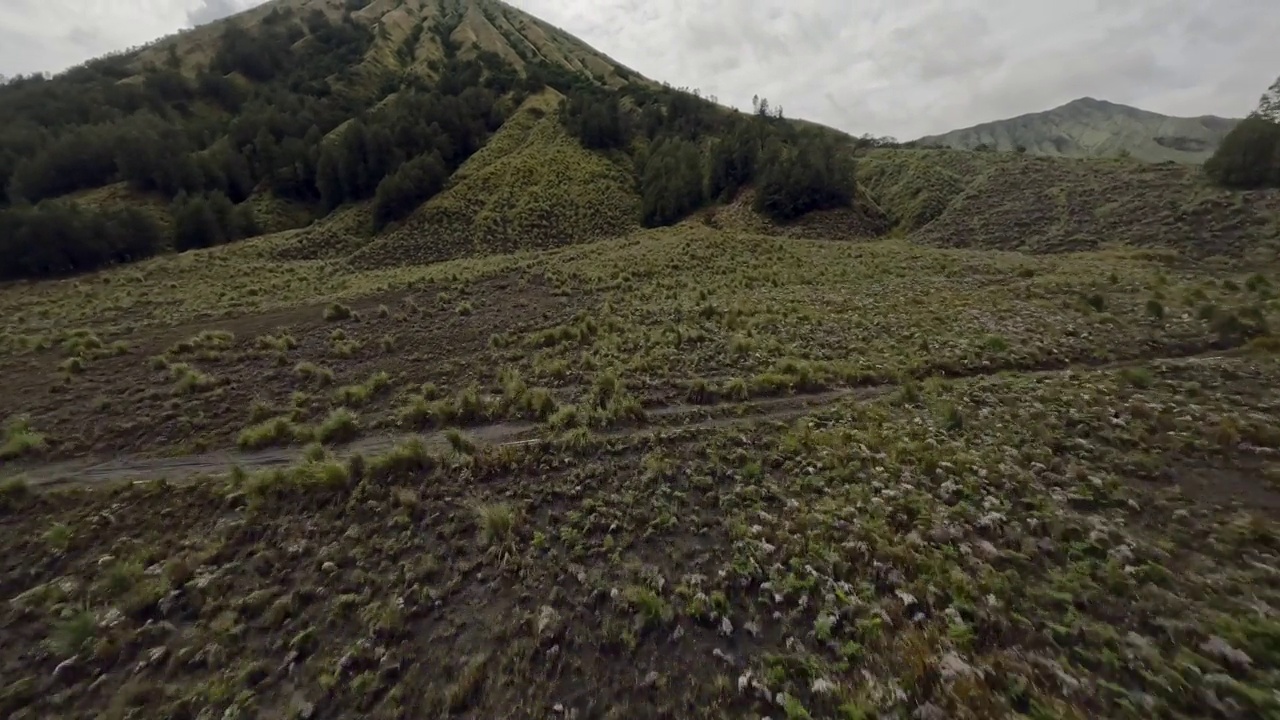 土地车Enduro骑手驾驶火山自然丘陵越野轨道山地植被鸟瞰图视频素材