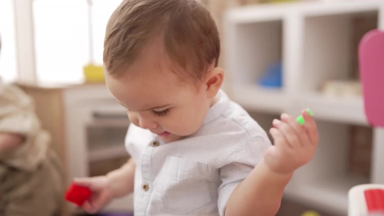 两个可爱的幼儿站在幼儿园玩积木视频素材