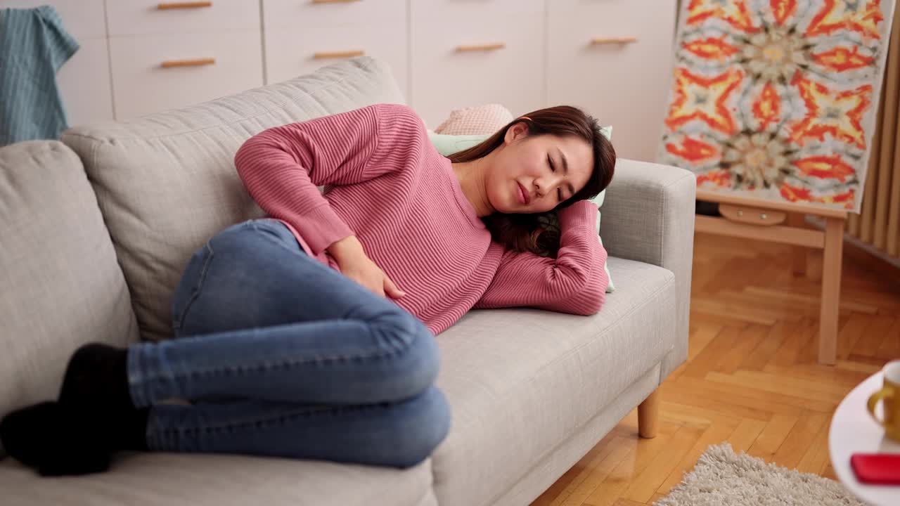 年轻女子在家经期痉挛视频素材