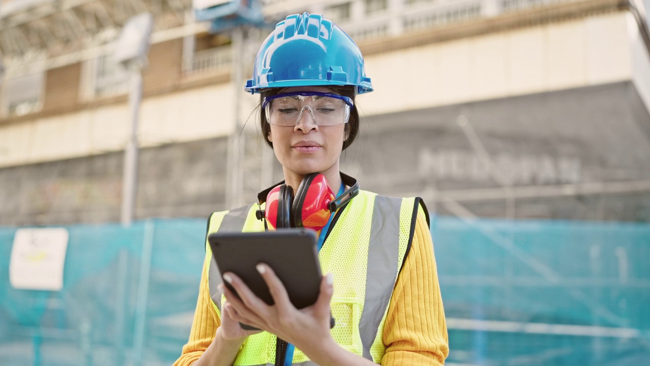 年轻美丽的西班牙女建筑师在街上使用触摸板视频素材