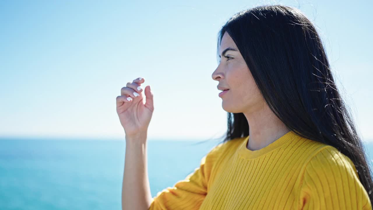 年轻美丽的西班牙女子站在海边轻松的表情视频素材