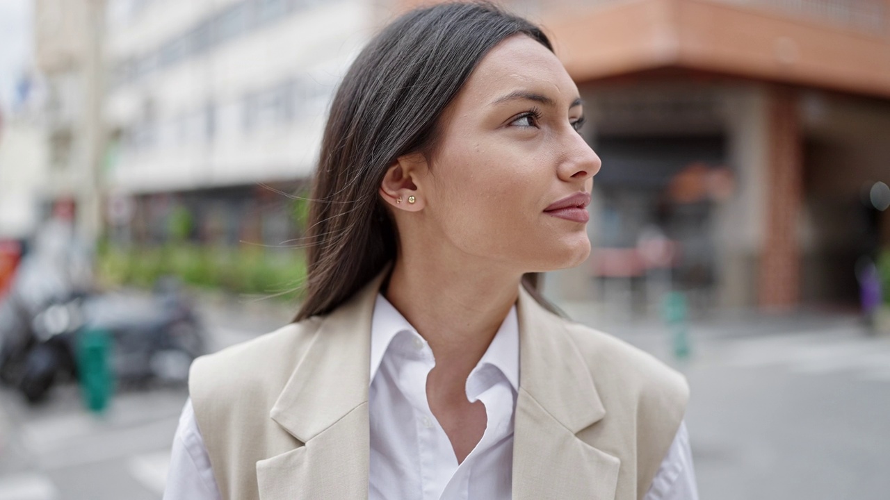 年轻美丽的西班牙女人微笑自信地站在街上视频素材