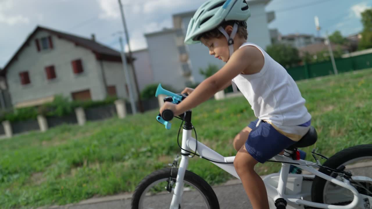 快乐的孩子戴着头盔在城外自行车道上骑自行车。活跃的小男孩在户外锻炼视频素材