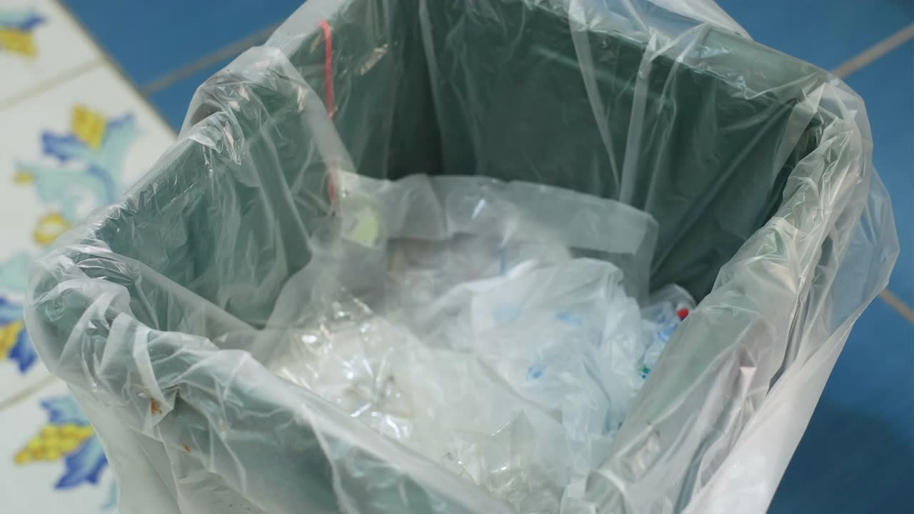男士手上的垃圾用过的塑料瓶放在单独的垃圾收集箱上，回收利用视频下载