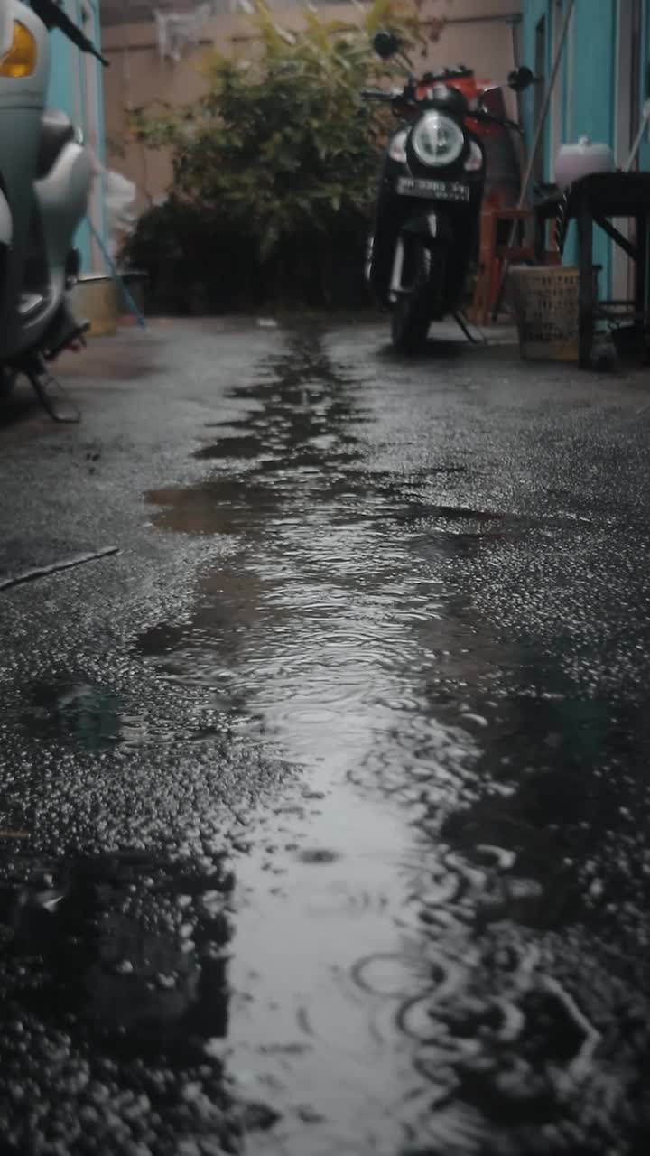 下午下雨的视频，背景是2辆摩托车和水坑视频素材