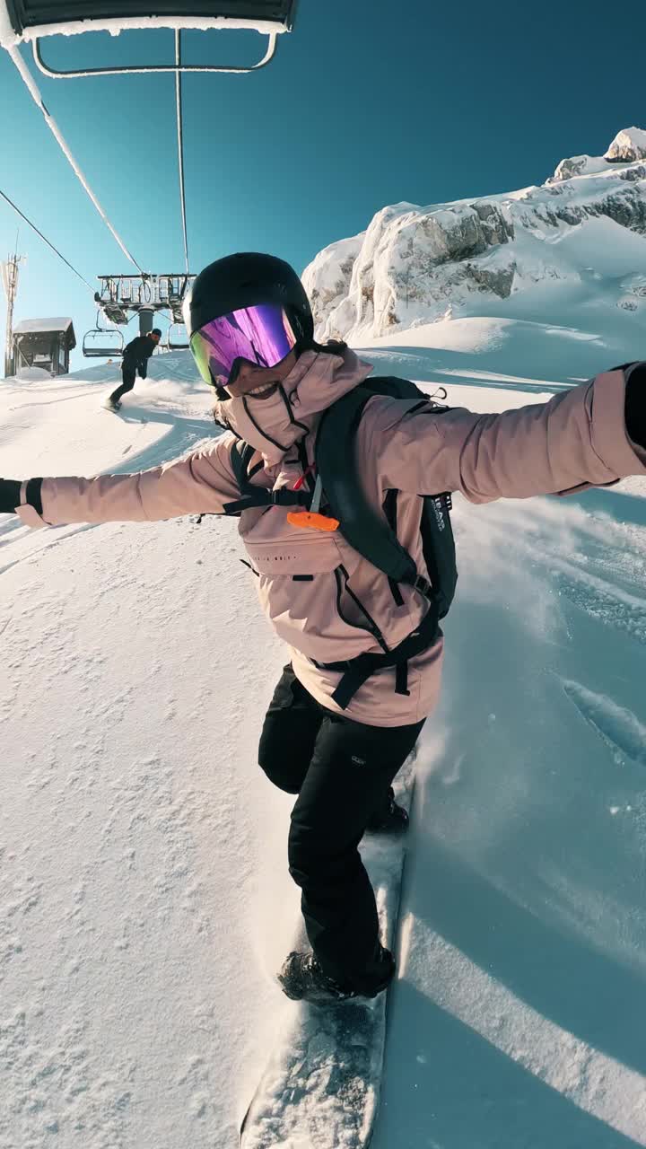 冬天的冒险:一个美丽的拍摄视频的年轻女子单板滑雪的美丽和刺激的季节。太阳正照在他身后的山脊上。股票视频视频素材