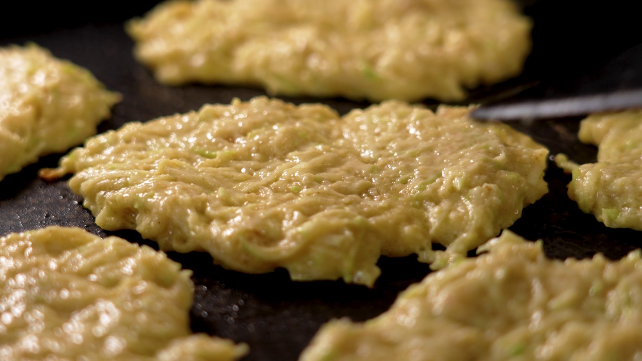 在平底锅里煎蔬菜西葫芦煎饼。烹饪油煎饼视频素材