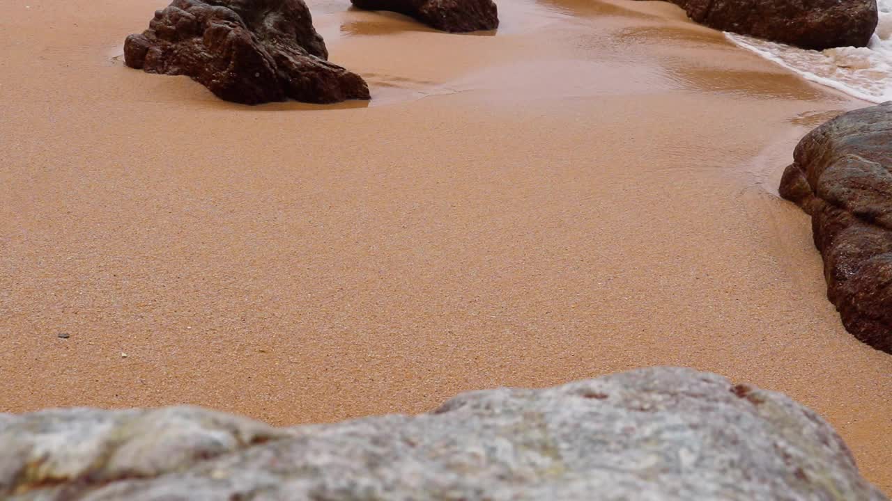 美丽蔚蓝的大海，浪花翻滚，海浪在沙滩上翻滚着石头视频素材