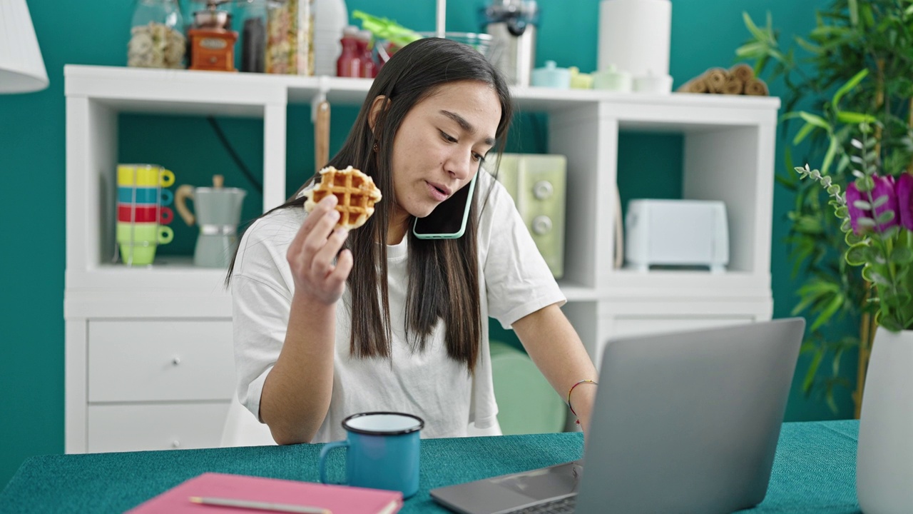 年轻漂亮的西班牙女人在餐厅用智能手机吃早餐视频素材