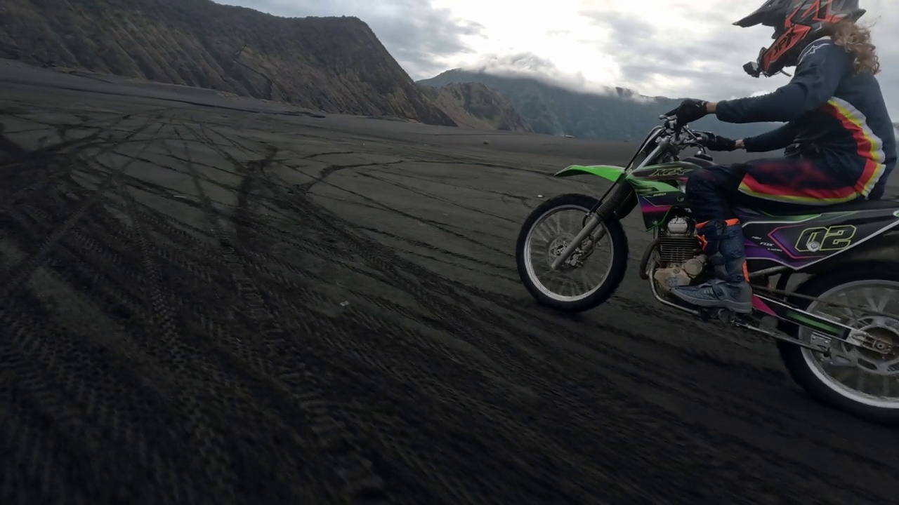 男子骑土车Enduro跳跃速度骑在熔岩田附近的火山摩托车视频素材