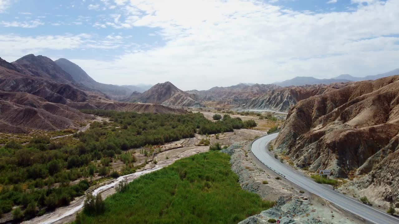 航拍的道路被沙漠山脉和树木包围视频素材