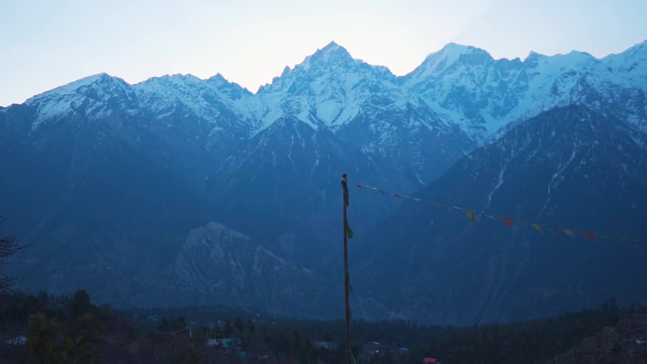 从印度喜马偕尔邦的卡尔帕村看到，白雪覆盖的喜马拉雅山脉和神圣的金纳尔冈仁波齐峰。日出时雪山的景色。卡尔帕村寒冷的冬日早晨。视频素材