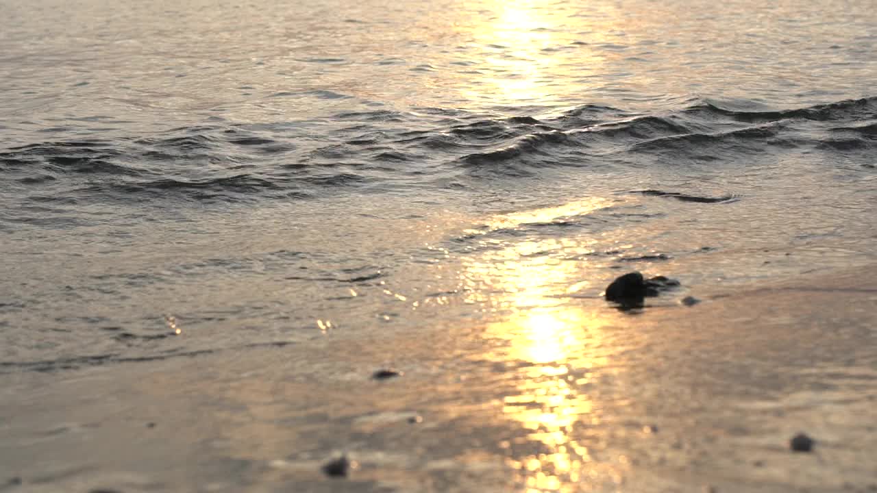 在萨索斯，海浪在日落时溅在海滩上视频素材