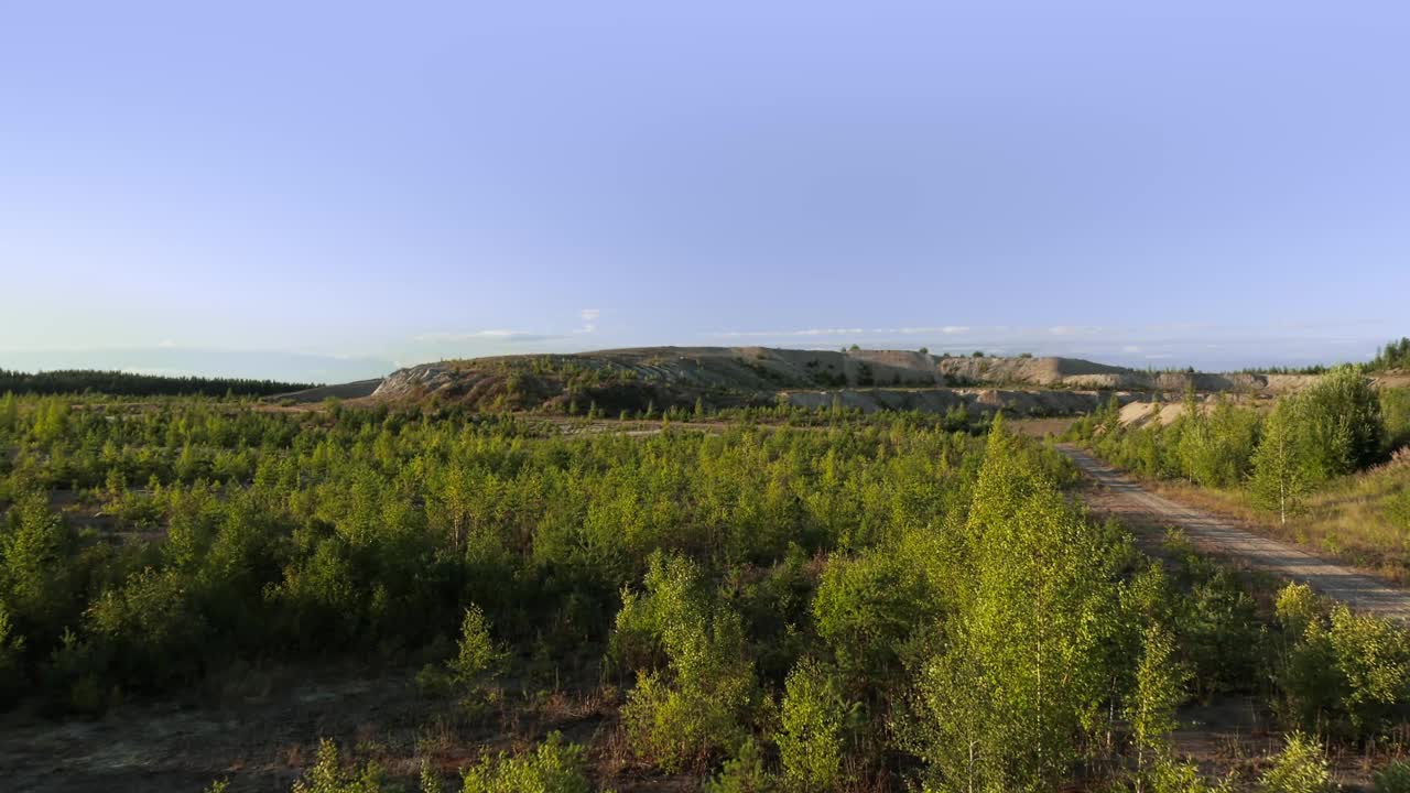 缓慢地向前飞行，越过森林重新开垦的荒地，飞向远方的山丘视频下载