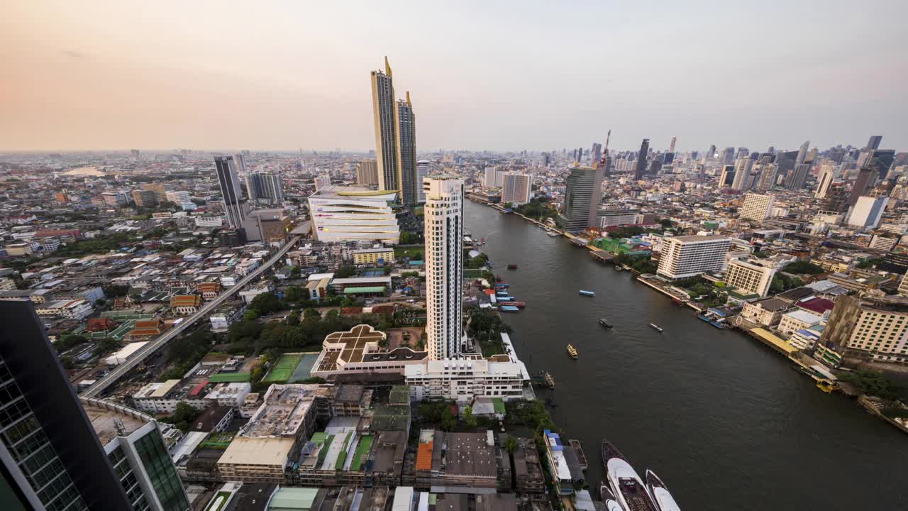 鸟瞰曼谷城市的夜景，在Chao Phaya河滨和横跨中央商务区的桥上。视频素材