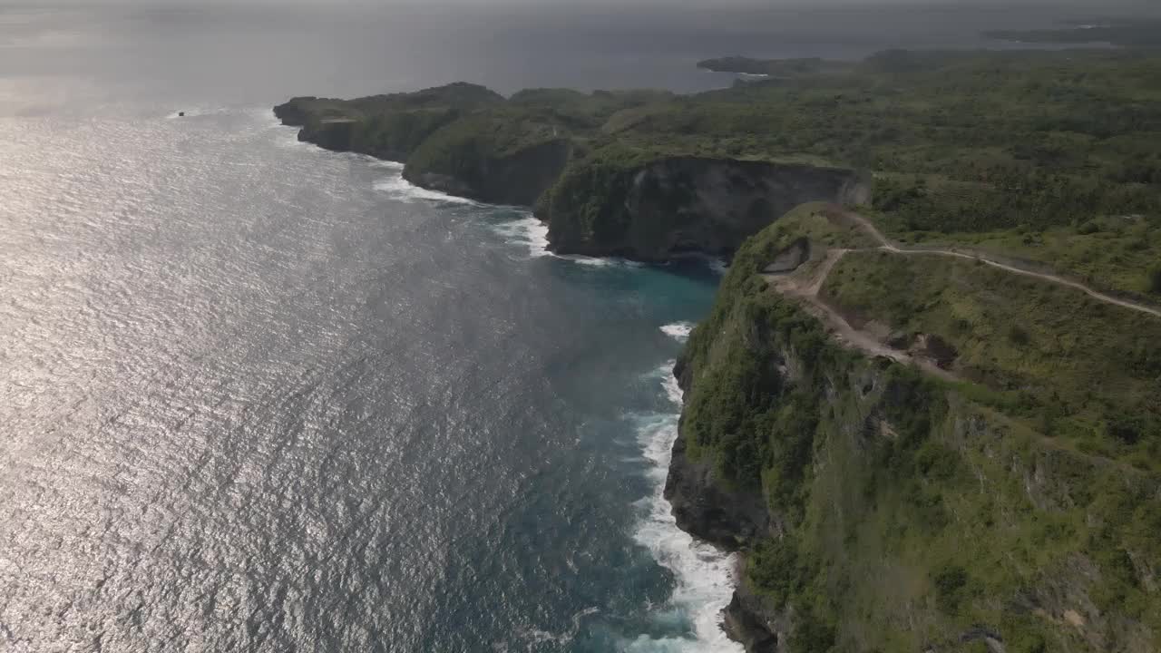 印度尼西亚巴厘岛努沙佩尼达岛的热带海岸柯灵金海滩与蓝绿色海的鸟瞰图视频素材