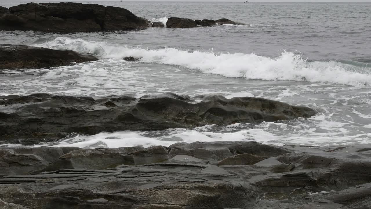 波浪拍打着海边的岩石。视频素材