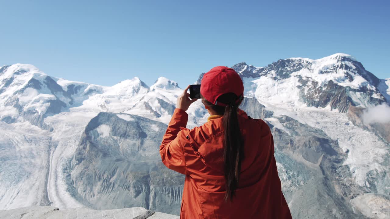 女游客用智能手机在瑞士阿尔卑斯山拍照视频素材