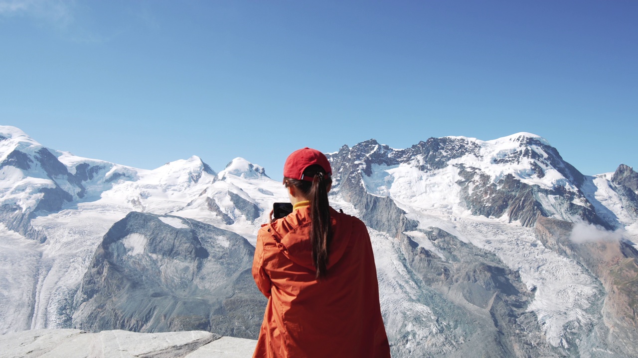 女游客用智能手机在瑞士阿尔卑斯山拍照视频素材