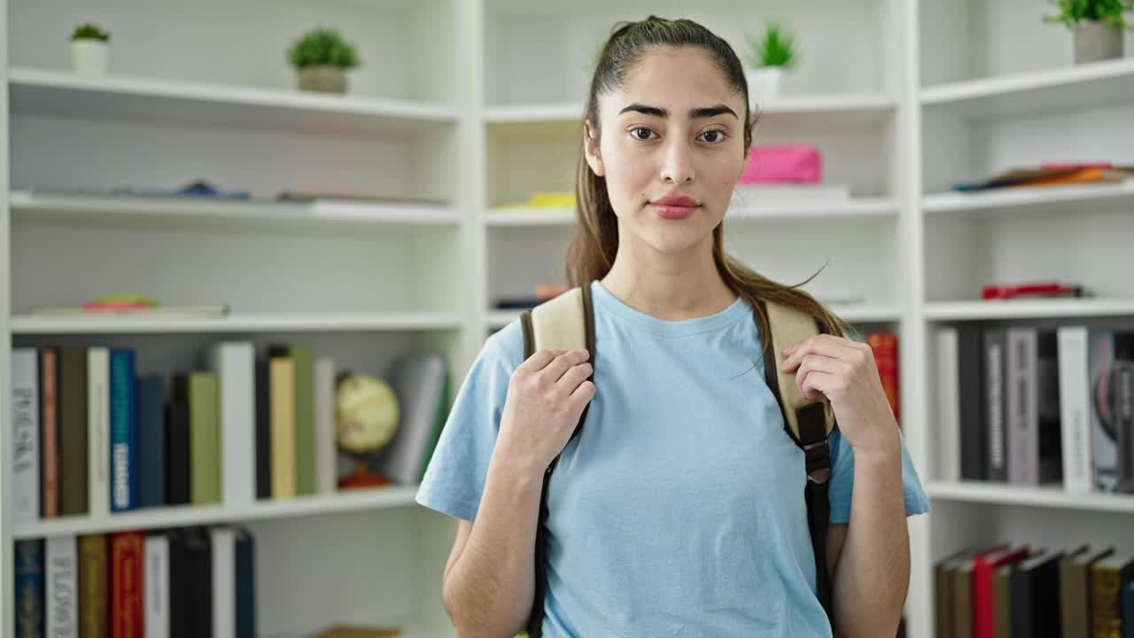 年轻美丽的西班牙女学生微笑自信地站在图书馆大学视频素材