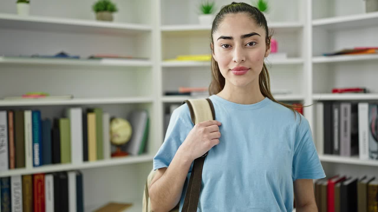 年轻美丽的西班牙女学生微笑自信地站在图书馆大学视频素材