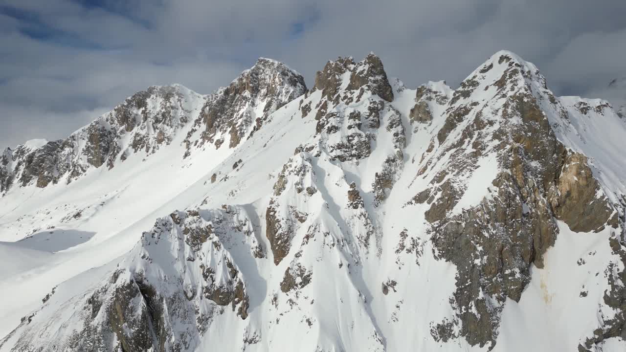 空中拍摄的落基山脉在一个阳光明媚的冬天完全被雪覆盖视频素材