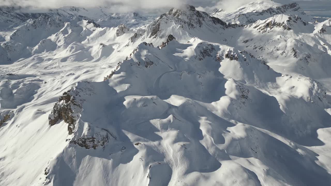 空中拍摄的落基山脉在一个阳光明媚的冬天完全被雪覆盖视频素材