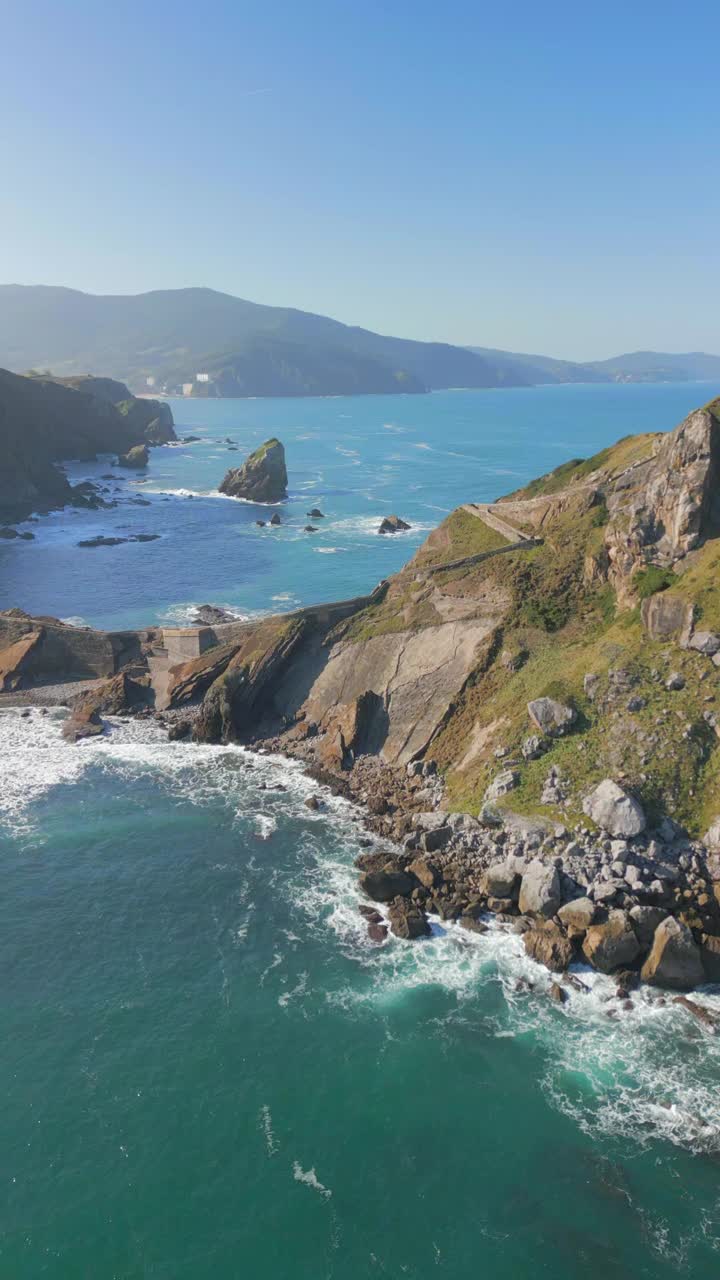 空中垂直视频的建筑在岩石山的顶峰上的海岸视频素材