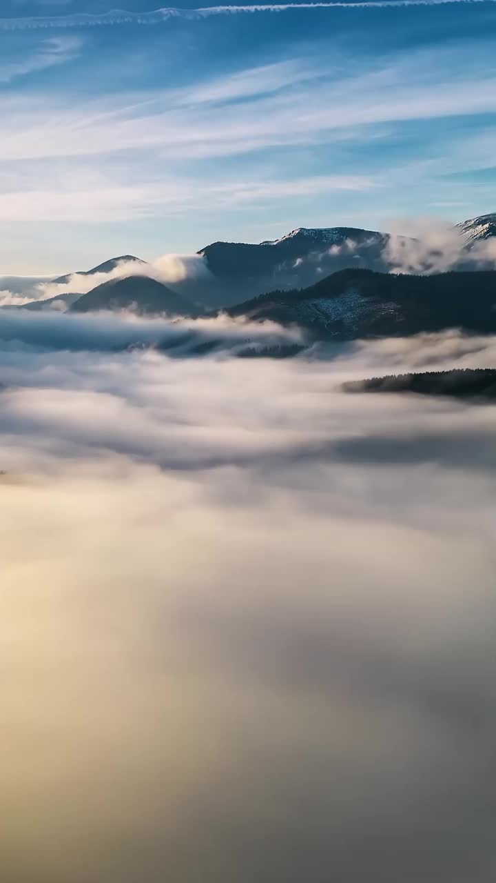 垂直空中全景云雾山脉景观与雾天运动在自然日出超延迟视频素材