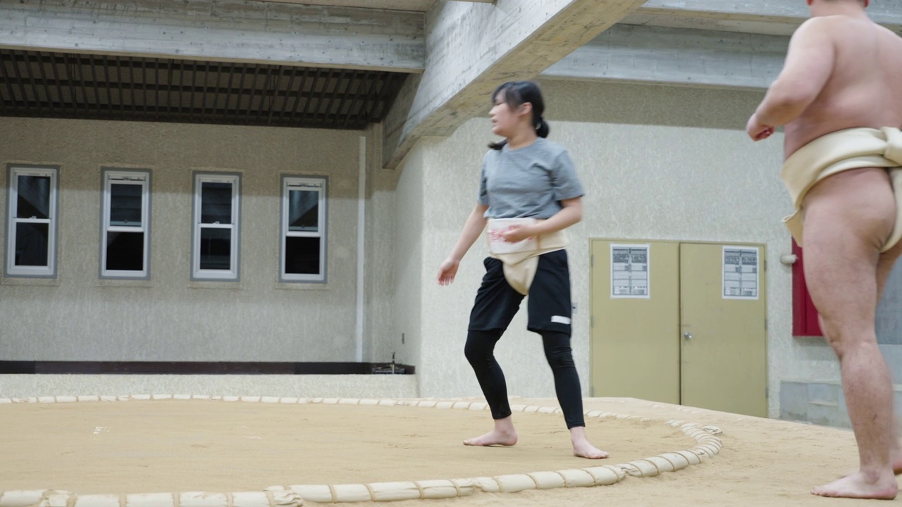 年轻的小学年龄女孩摔跤与她的教练在相扑练习视频下载