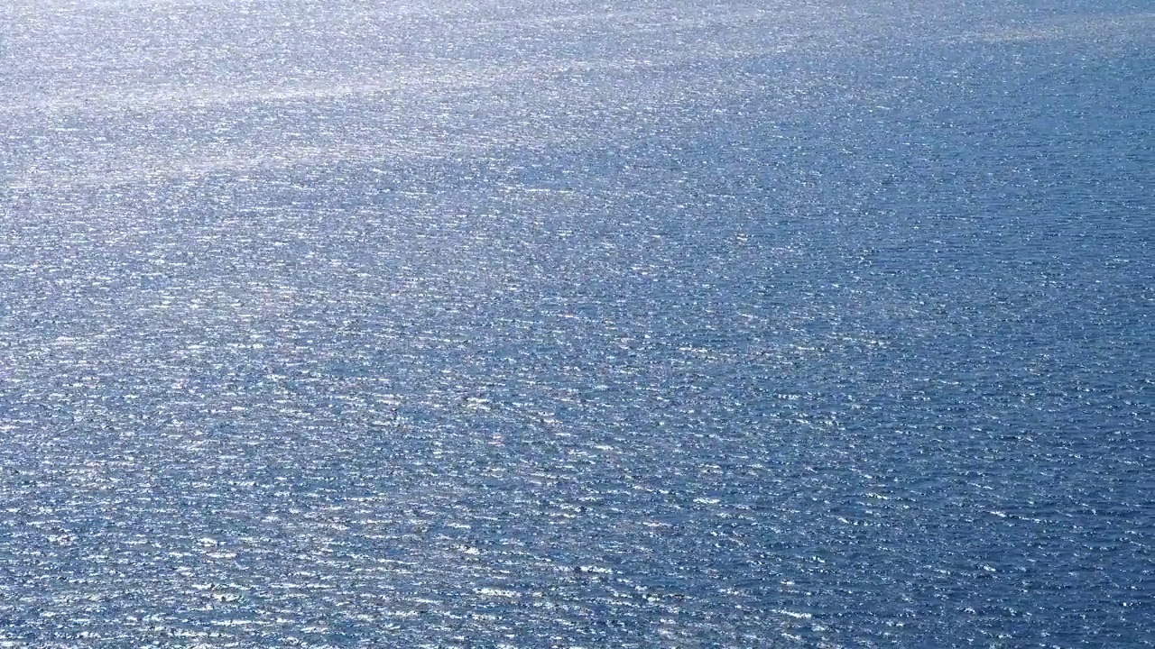 鸟瞰水晶般清澈的海水纹理。从上面看，自然的蓝色背景。碧水反射。蓝色的海浪。夏天海洋。无人机俯视图视频素材