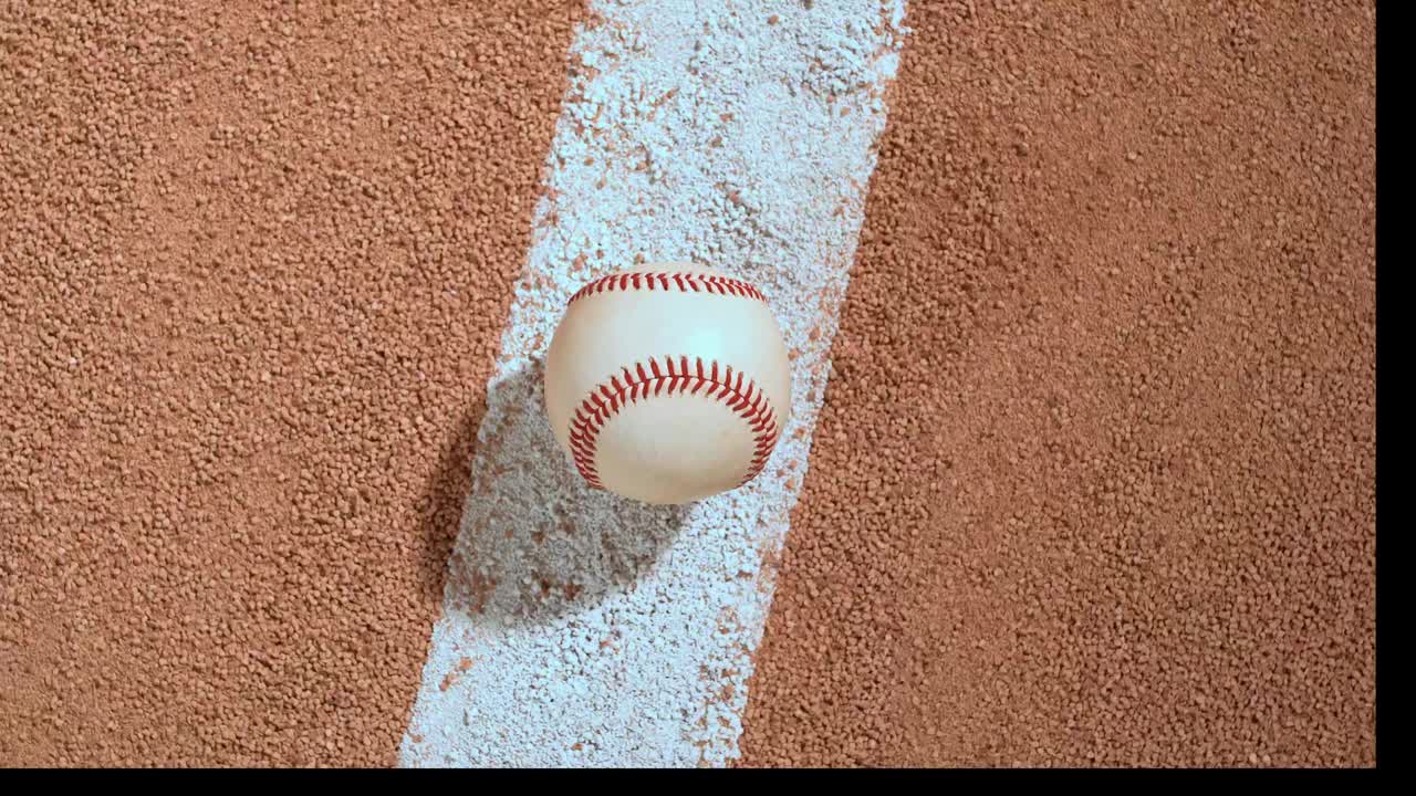 An overhead view of a baseball sitting on the infield baseline as the camera rotates and zooms in – fast视频下载