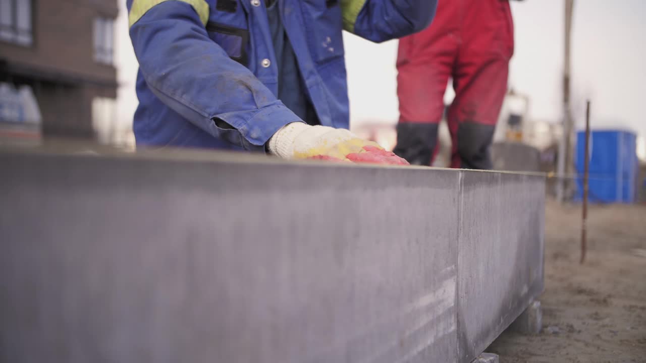 工人安装路缘。建筑工人在建筑工地工作视频素材