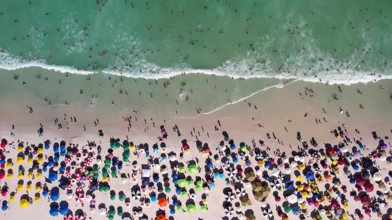 无人机在美丽的海滩上飞行的鸟瞰图，海浪和水从顶部角度在里约热内卢里约热内卢的沙滩上坠毁，卡波弗里奥-巴西视频素材