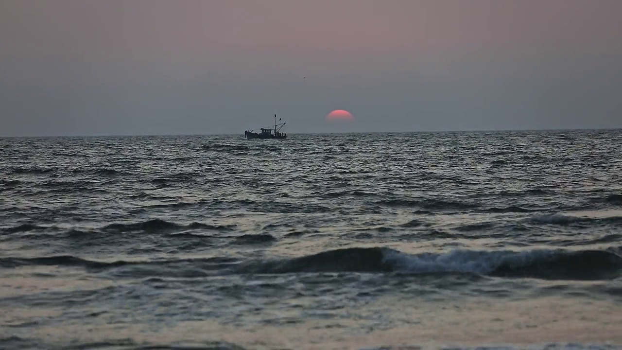 海上日落或日出的空中电影视图和一艘漂浮的船视频素材