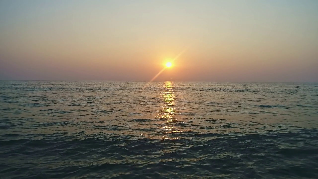 海面上平静的海浪，鸟瞰美丽的日落视频素材