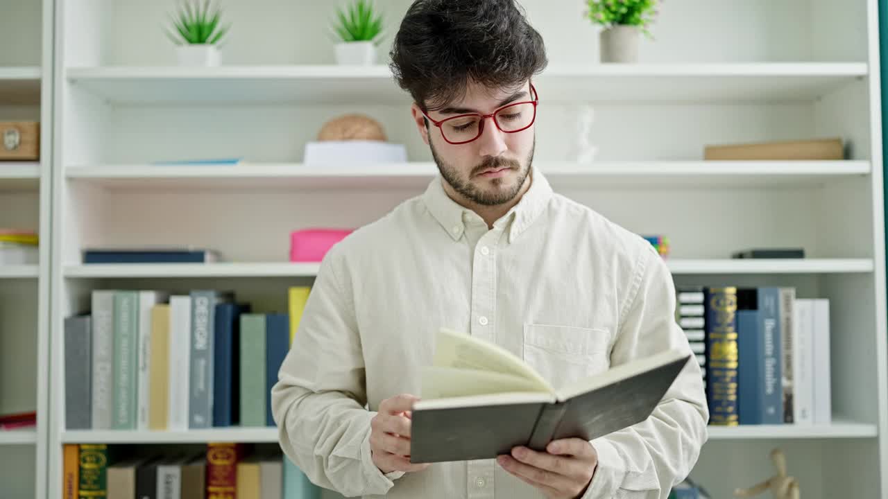 年轻的西班牙裔学生站在图书馆读书视频素材