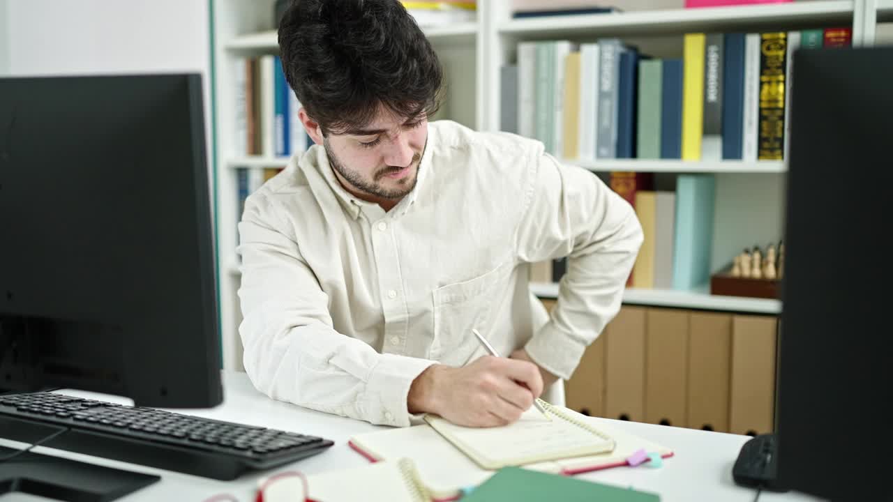 年轻的西班牙裔学生背疼在图书馆大学写笔记视频素材