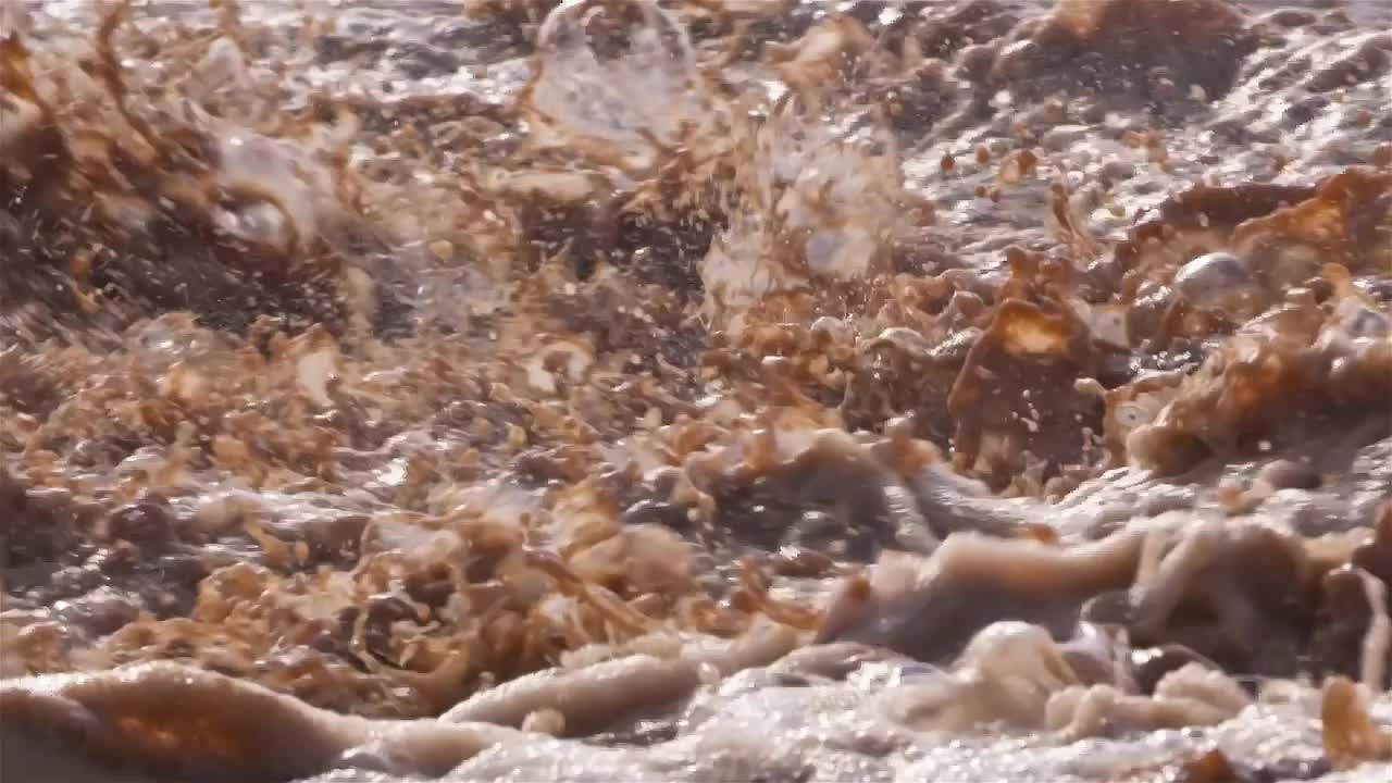 暴雨后泥泞的河流溅起水花慢镜头视频素材