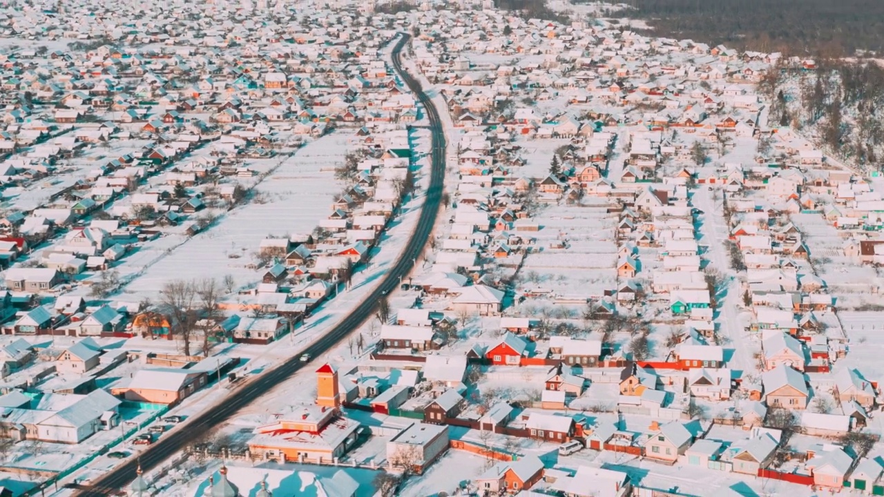 阳光明媚的冬日时光流逝。鸟瞰小镇村庄城市景观天际线交通在雪景。住宅鸟瞰图。时间流逝视频素材