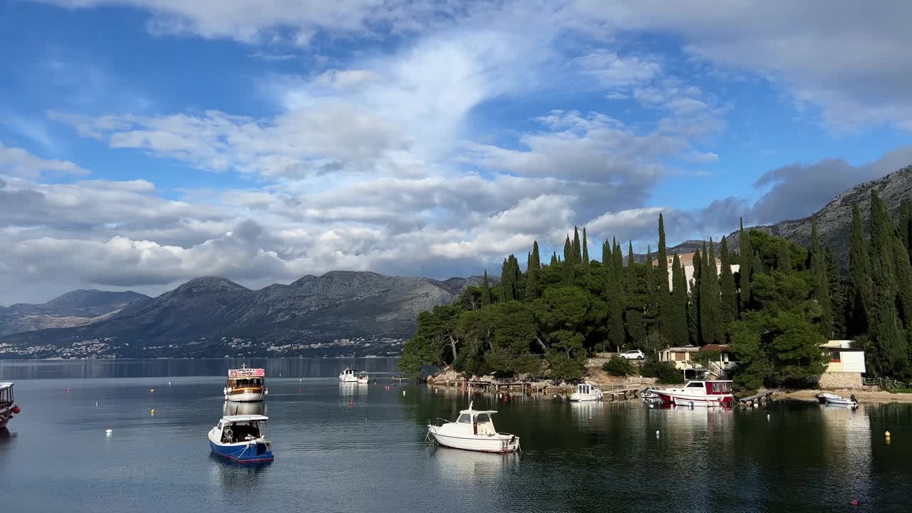 船只和游艇停泊在绿色多山海岸附近的海上视频素材