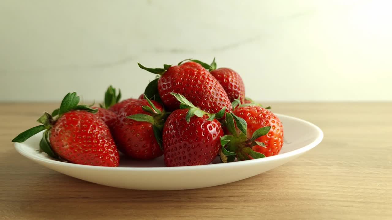 用手把从当地市场买来的新鲜草莓放到盘子里视频素材