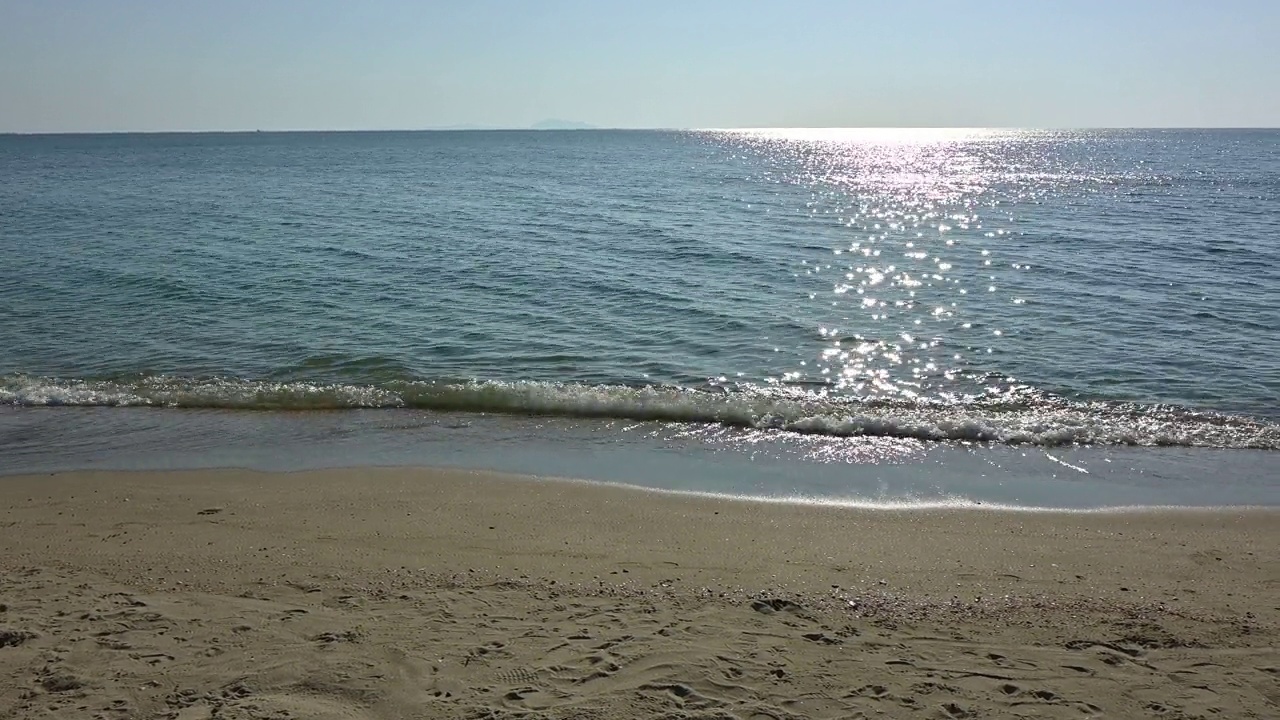 沙滩上的海浪和美丽的阳光在假期的早晨闪闪发光视频素材