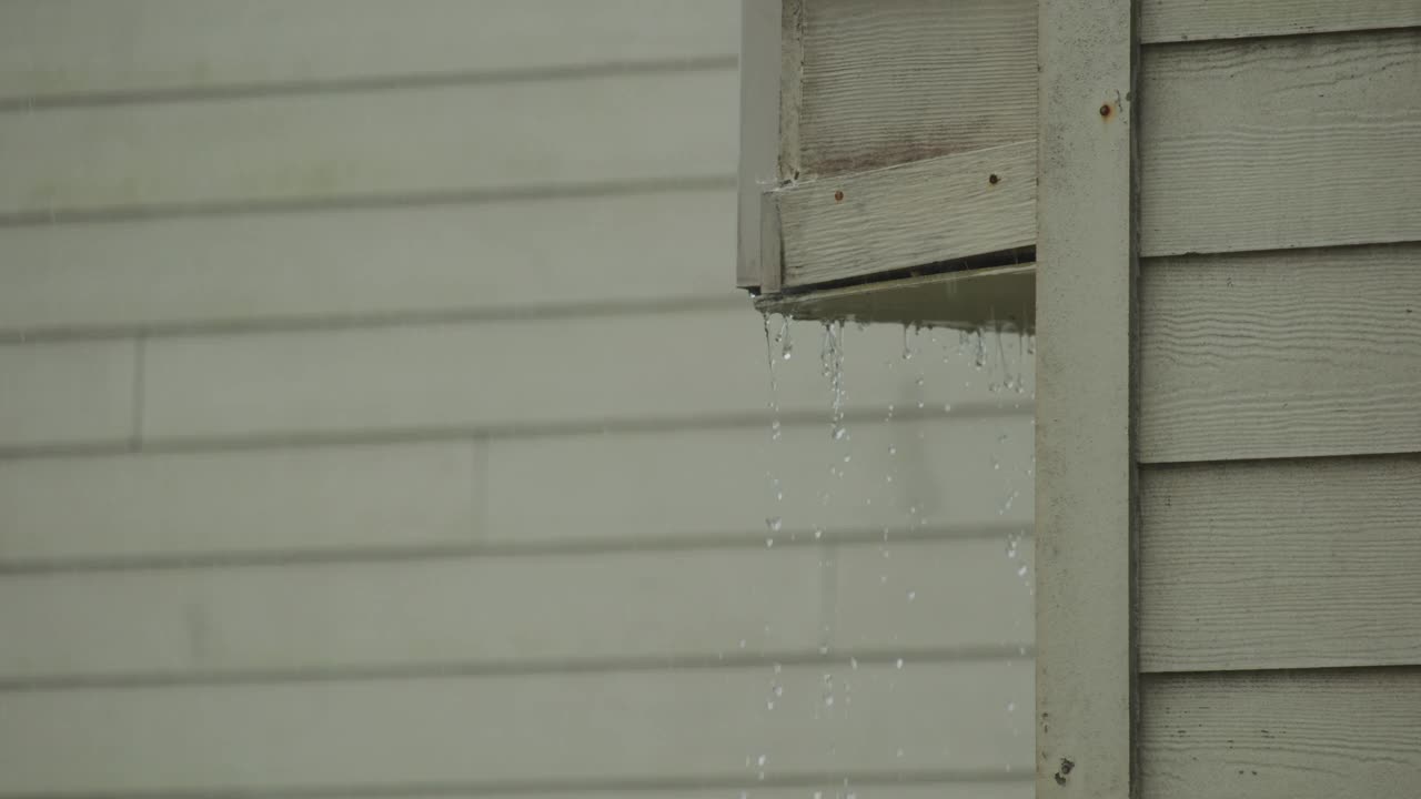 暴雨袭击屋顶和雨沟。慢镜头视频素材