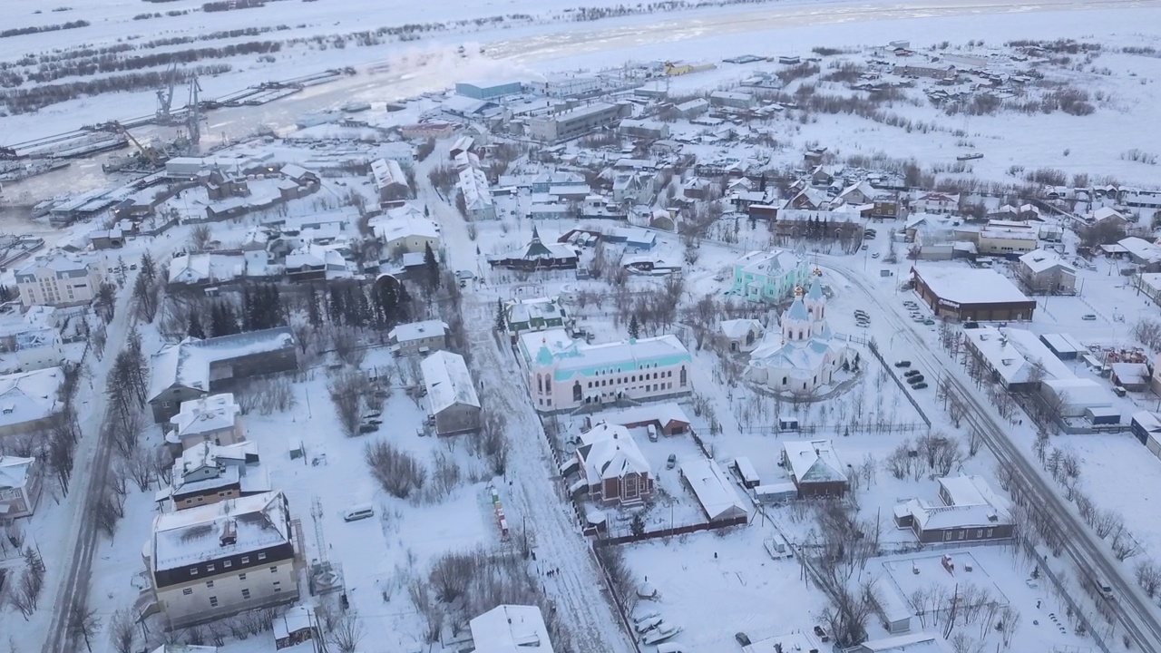 冬季小镇工业区的鸟瞰图。夹。雪覆盖了树木和建筑物视频素材