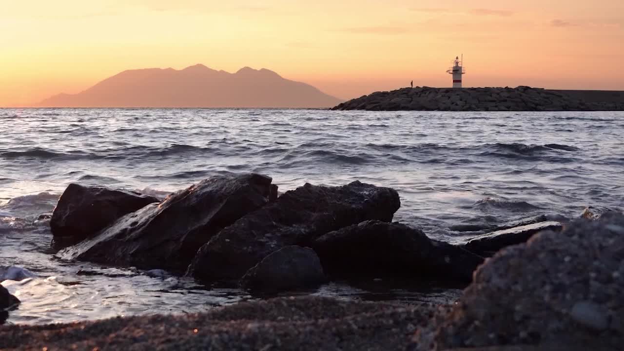 从Gokceada俯瞰Samothrace岛的灯塔日落海景视频素材