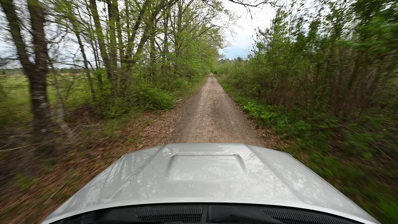 在狭窄的土路上开车，在泥坑里溅起水花视频素材