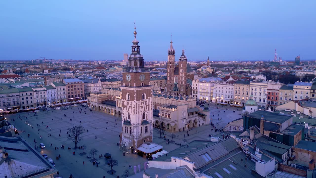 克拉科夫主要市场广场夜间无人机鸟瞰图。照明纪念碑:Mariacki(圣玛丽)教堂，Sukiennice(布厅)和市政厅塔视频素材